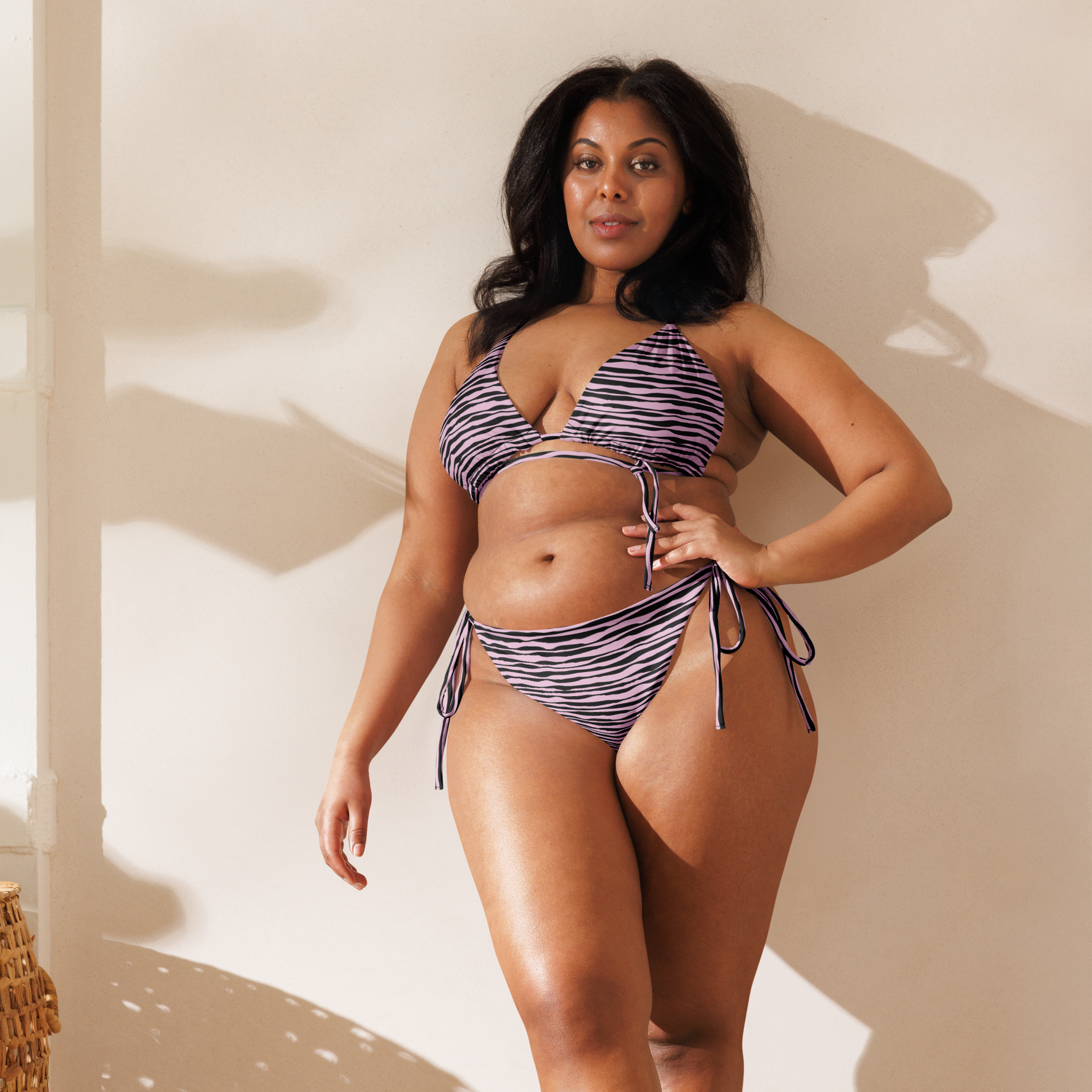 Kleiner rosafarbener String-Bikini mit schwarzen Linien
